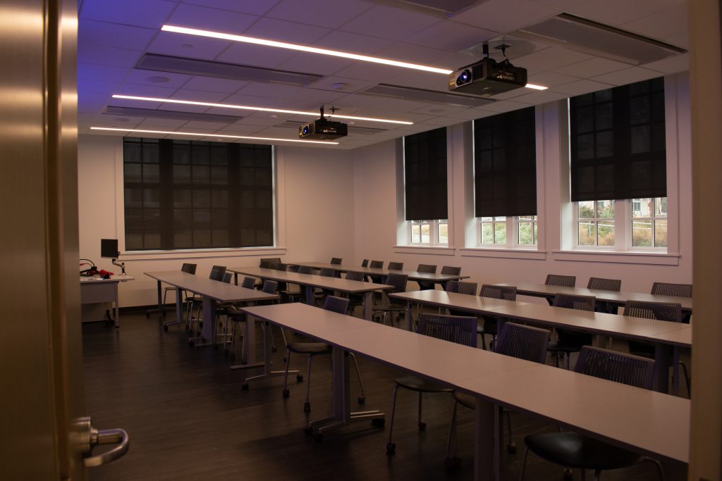 An image of an empty classroom. The room is clean, has large windows and new furniture.