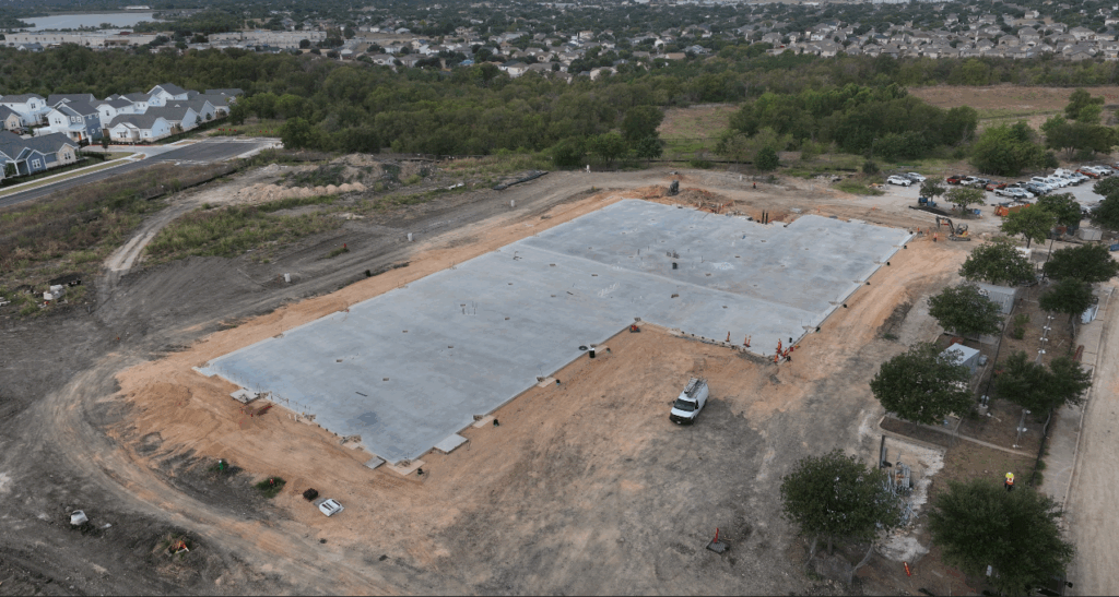 slab of concrete with dirt around it. This is the foundation for the building coming