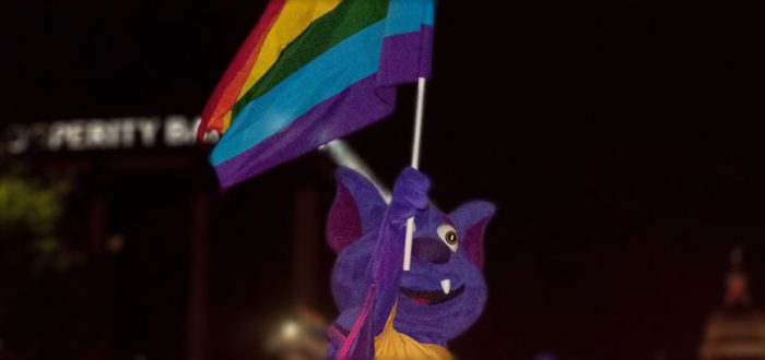 r.b. holding pride flag
