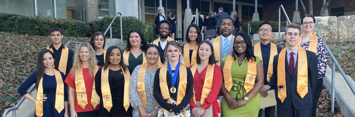 phi theta kappa gathers for a photo after an induction ceremony