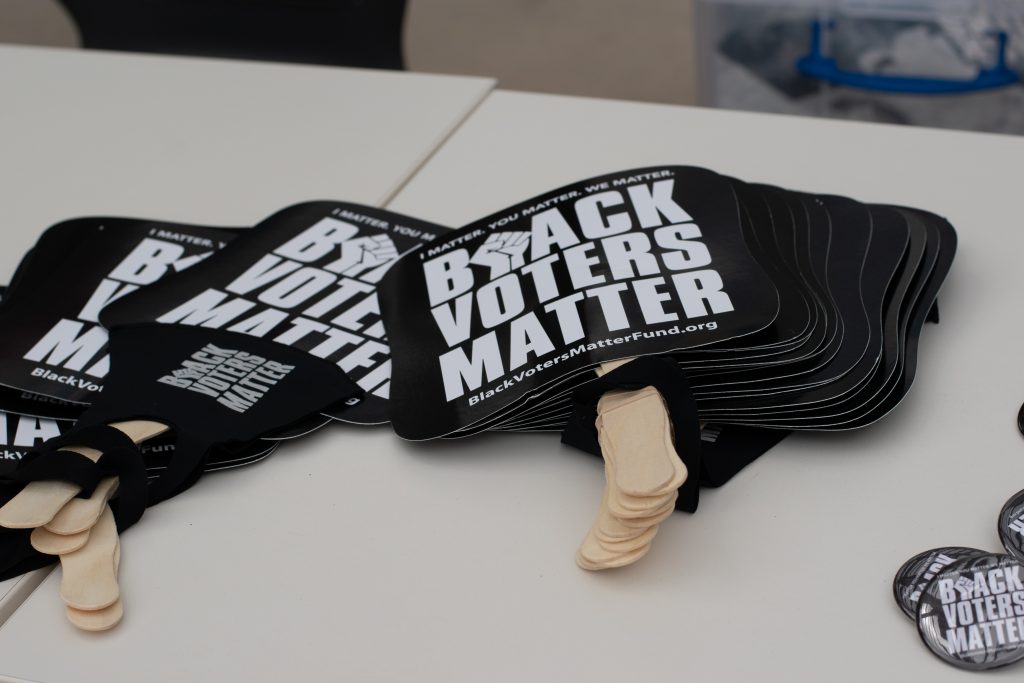 A table with Black Voters Matter swag like fans, face masks and buttons that the organization was passing out to students.