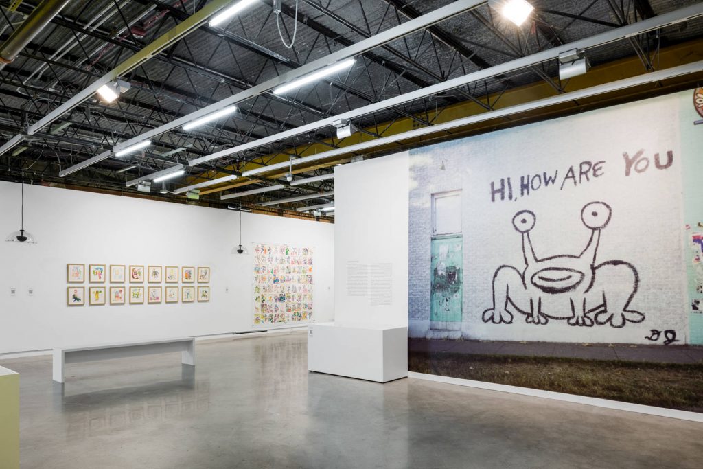 An art gallery filled with Daniel Johnston's work.