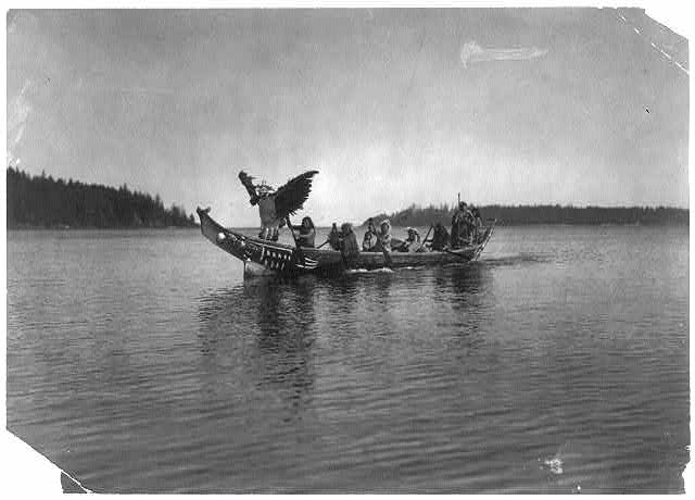 In the Bow, Qunhulahl, a Masked Man Personating the Thunderbird, Dances as Others Row to the Shore of the Bride's Village, Photo by Edward Curtis, Library of Congress