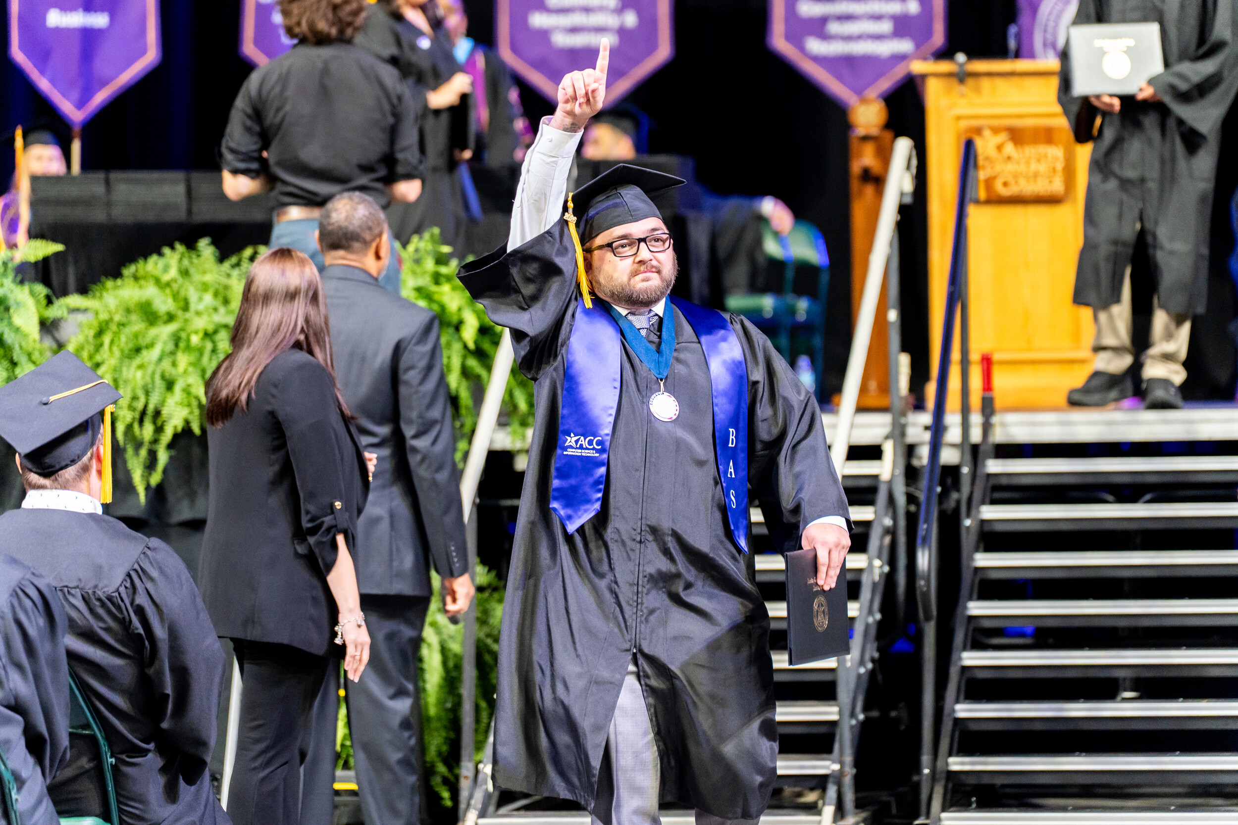 Austin Community College graduate of the BAS Software Development program in graduation regalia and BAS stole