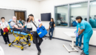 ACC ESMP students wheel in patient to Health Simulation Center