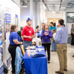 Students and employees talk during a job fair