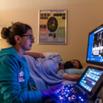 Sonography student looking at screen