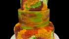 Three tiered cake colored in orange, green, brown, and yellow