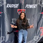 Photo of female student in front of Texas Tech banner