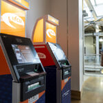 Two atms next to each other with student walking by in the background