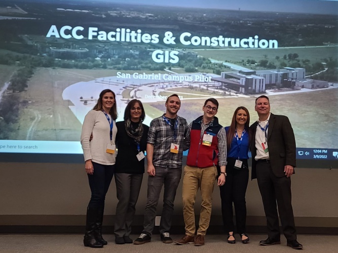 Six male and female representatives of ACC Facilities & Construction and Geographic Information Systems (GIS) standing in front of slide presentation