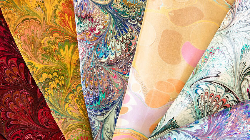Brightly colored fanned swatches of marbled fabric 
