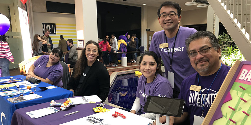 Career Services male and female staff at ACC Fest booth with promotional materials and giveaways