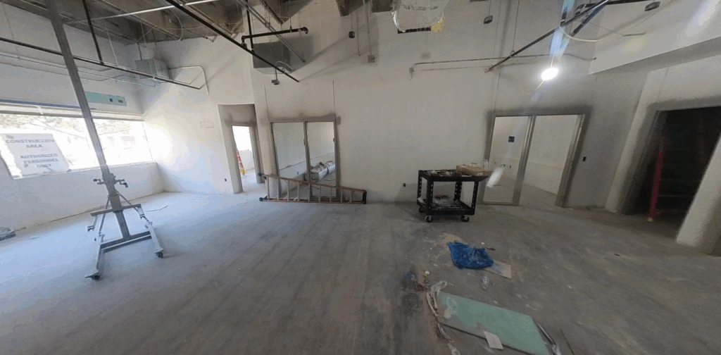 empty room under construction with concrete floor and open doors