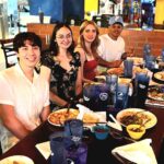 Angel (featured right center) celebrates farewell dinner with ACC friends and staff members who played an important role in his educational journey.