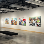 Gallery interior displaying several colorful paintings from Darla Barolini’s Lessons Learned: Selections from the American Classroom Series, with two black benches in the open exhibition space.